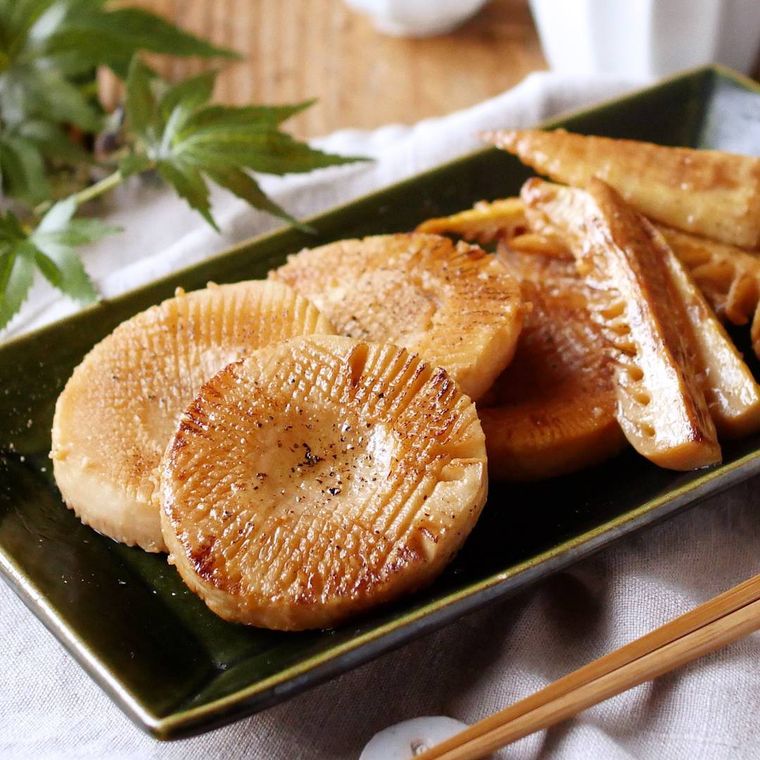 黒色の長方形の皿に盛られたたけのこのバターしょうゆステーキ