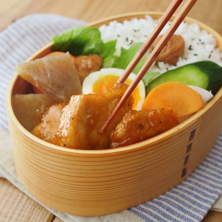 弁当箱に詰めた鶏むね肉の柚子胡椒照り焼きやゆで卵など