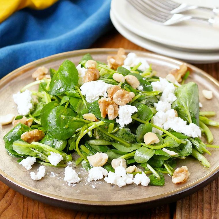 茶色くて丸い皿に盛られたクレソンのサラダ