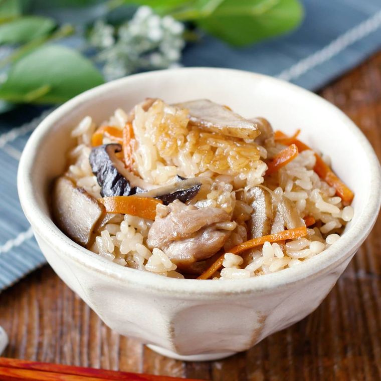 白い茶碗に盛られている干ししいたけのかしわ飯
