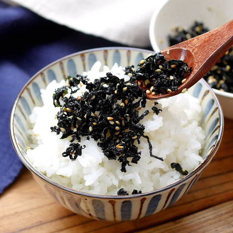青いライン模様入りの茶碗に盛られているごはんの上にあるわかめのふりかけ