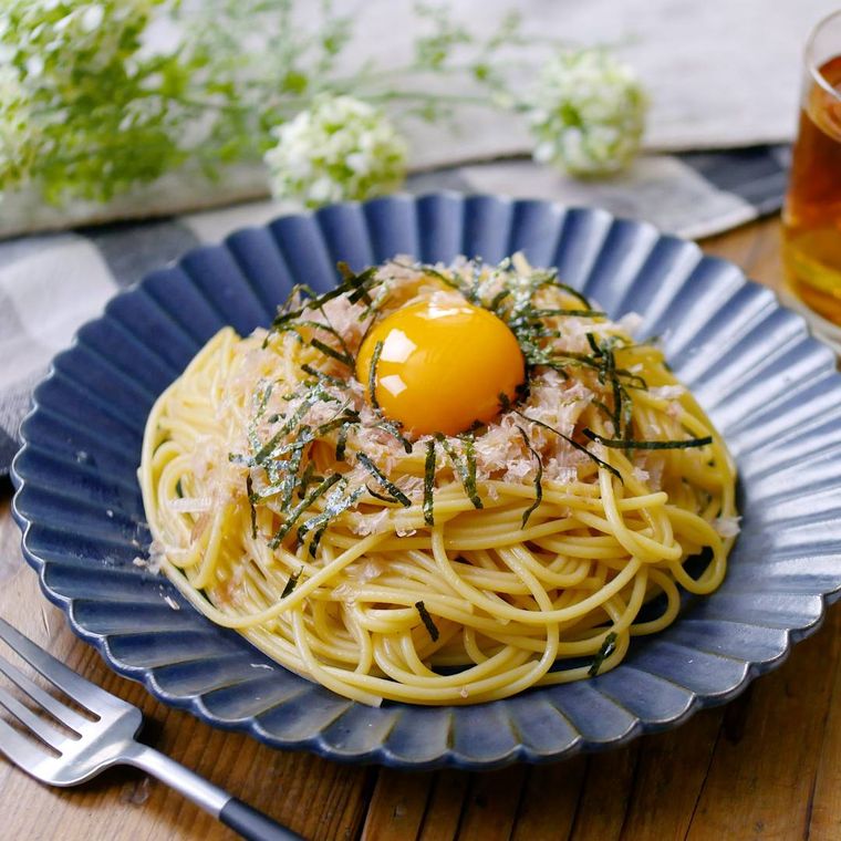 青い皿に盛られたたまごかけパスタ