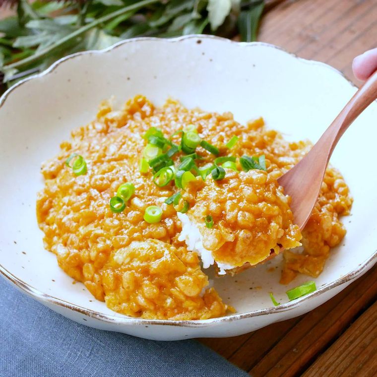 白い皿に盛りつけられた揚げ玉玉子丼をスプーンですくった様子