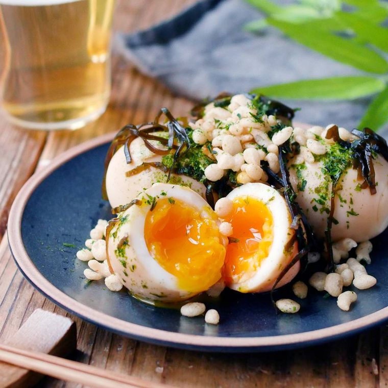 青い皿に盛りつけられた揚げ玉トッピングの塩こんぶ入り煮卵