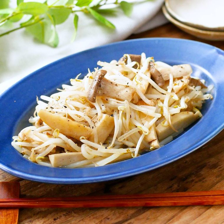 楕円形の青い皿に盛り付けられたエリンギのガーリックもやし炒め