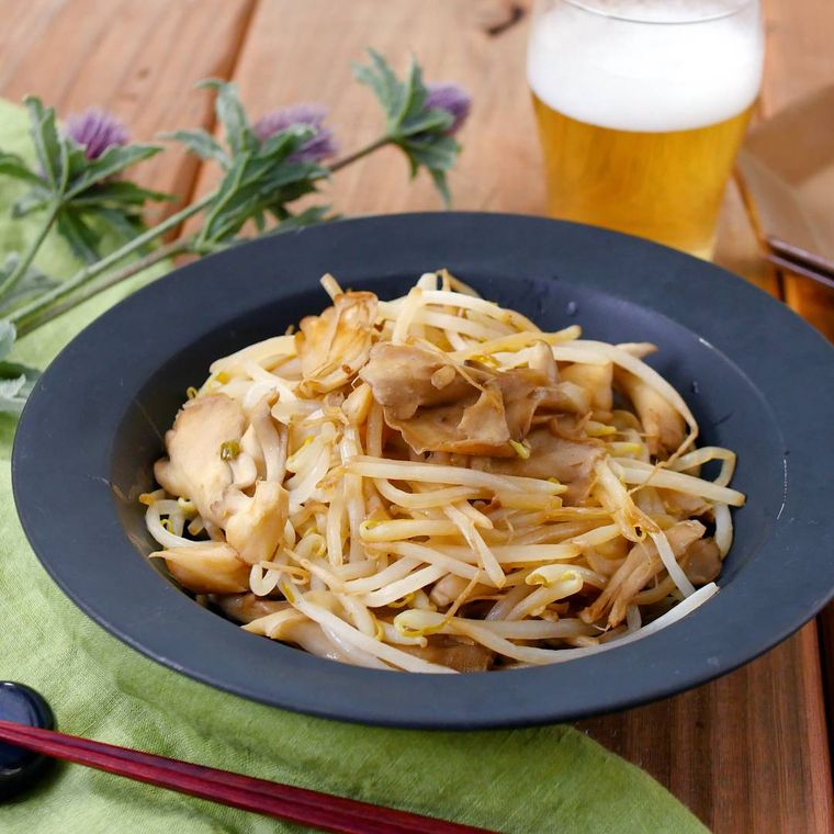 シンプルな黒い洋風の皿に盛り付けられたバターしょうゆのもやし炒め