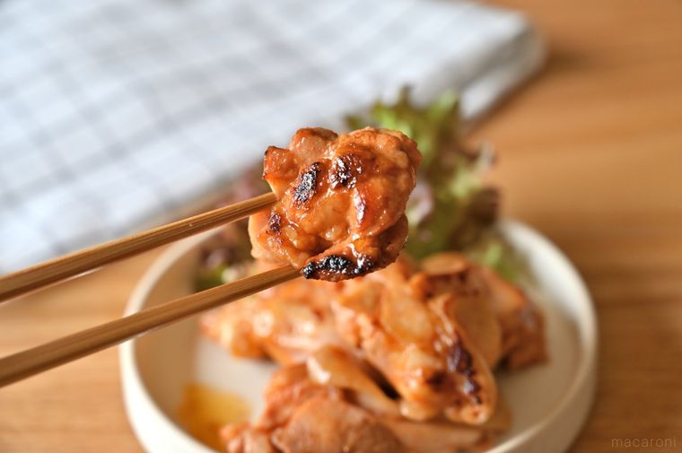 甘辛チキンを箸でつまみ上げている