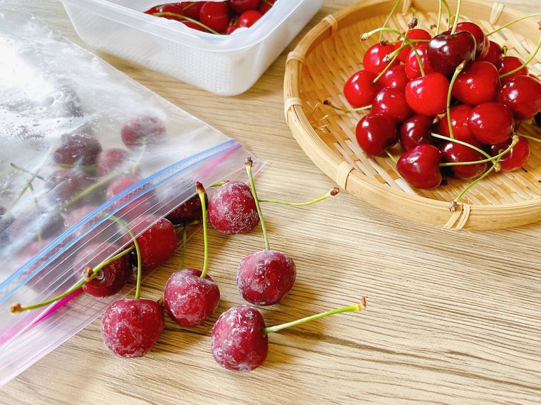 冷凍したさくらんぼと、ざるの上にある生のさくらんぼ