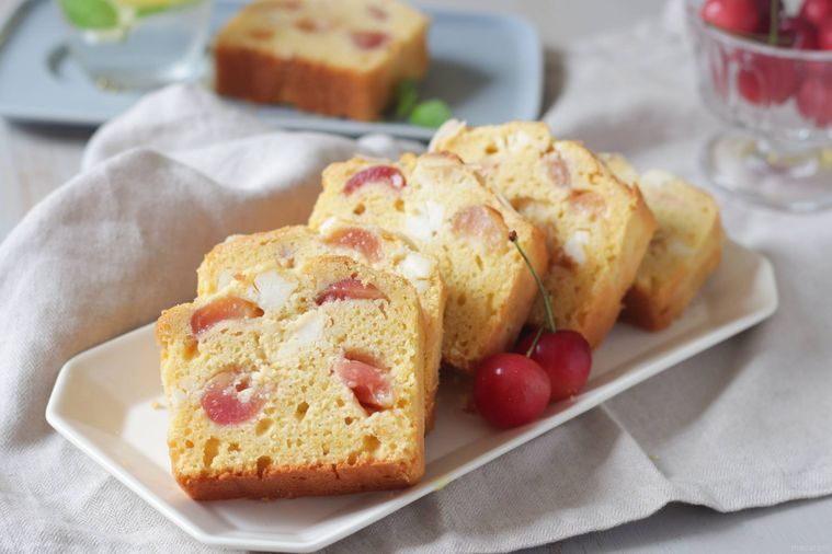 白いプレートの上の、切り分けたさくらんぼパウンドケーキ