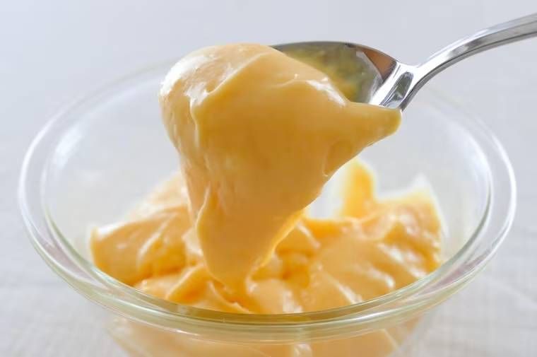 ボウルに入ったカスタードクリームをスプーンですくっている様子