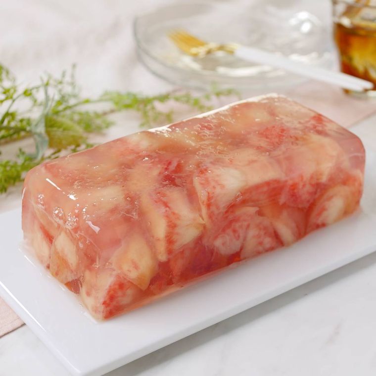 白い長皿に盛り付けた桃のゼリーテリーヌ