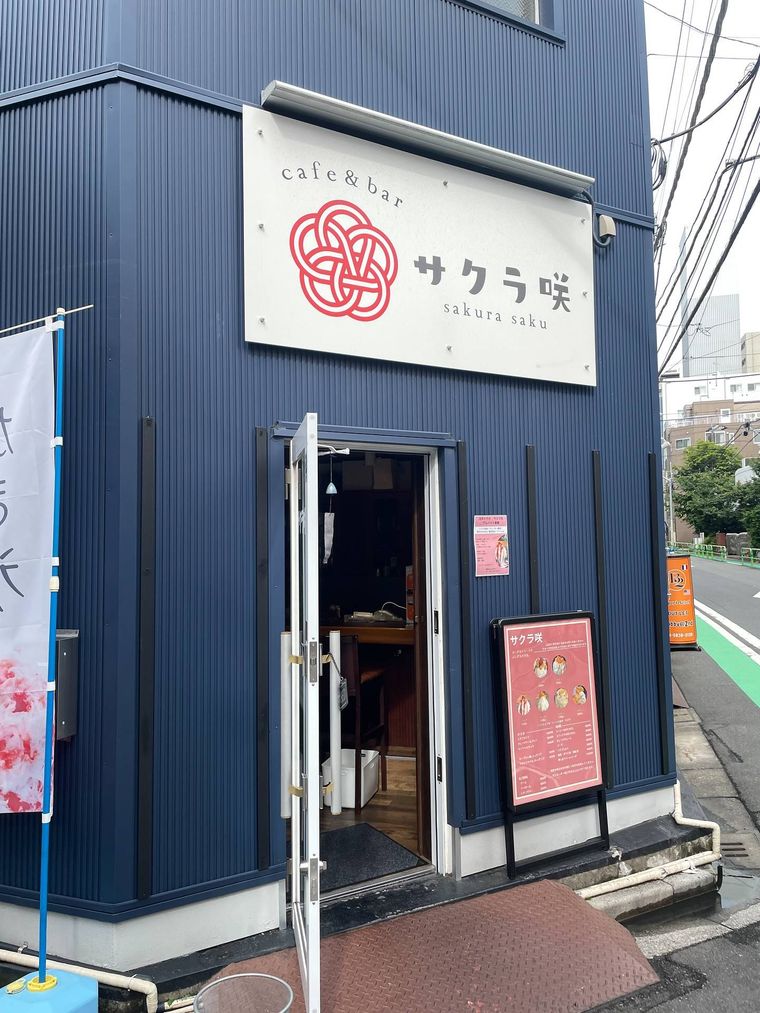 白い看板がついた店の青い外壁