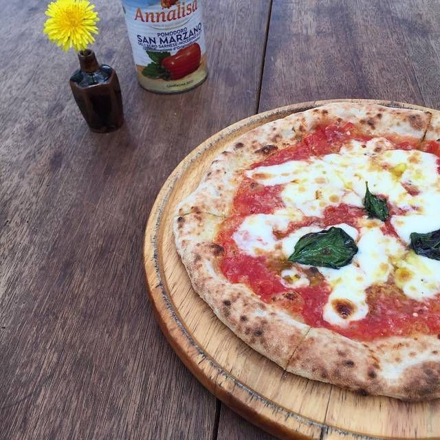 マルゲリータ・水牛モッツァレラと花瓶に入ったタンポポが置かれている様子