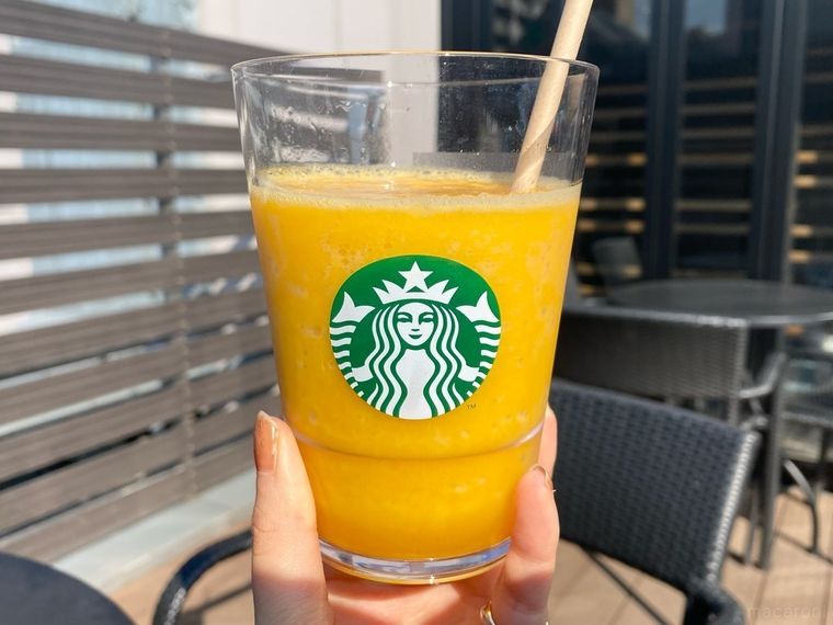 グラスに入ったマンゴーパッションティーフラペチーノを手に持っているイメージ