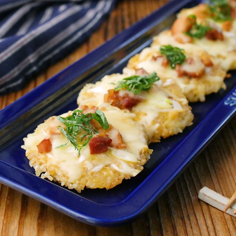 藍色の長皿に盛りつけられた焼き鳥と長ねぎ入り和風ライスピザ