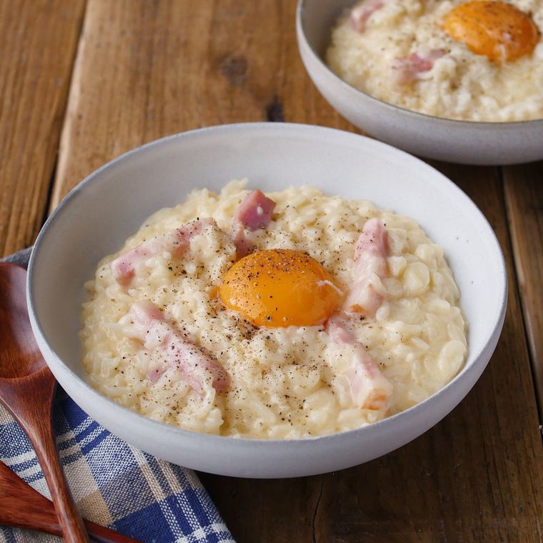 白い丼鉢に盛りつけられたベーコンと卵のカルボナーラリゾット