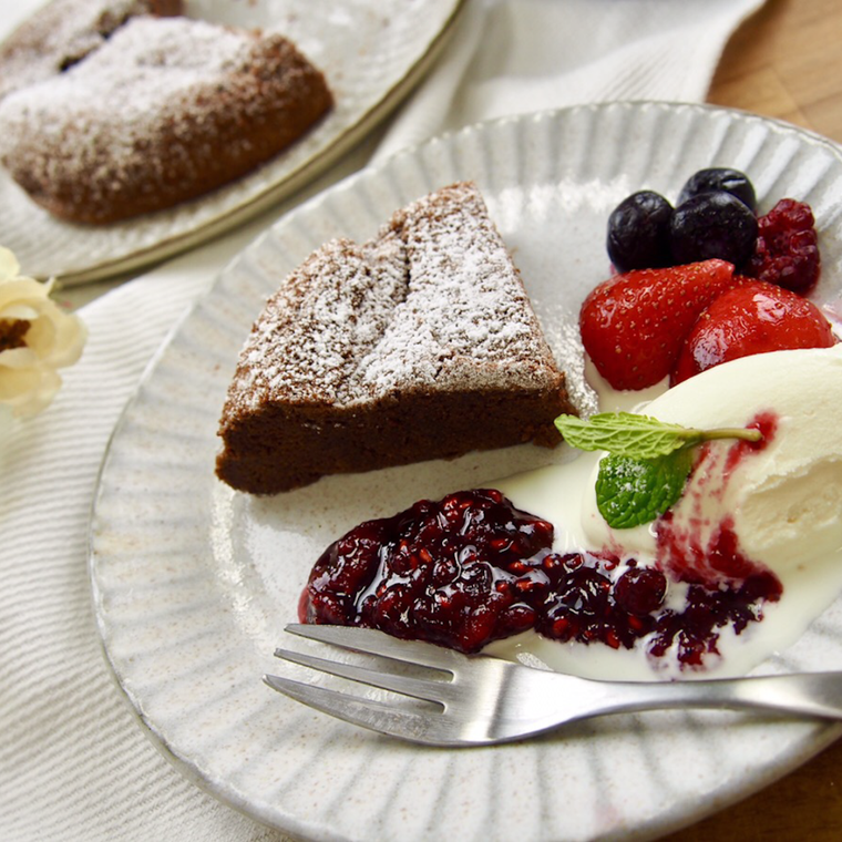 白い皿に盛られたガトーショコラとアイスクリーム、フルーツソース