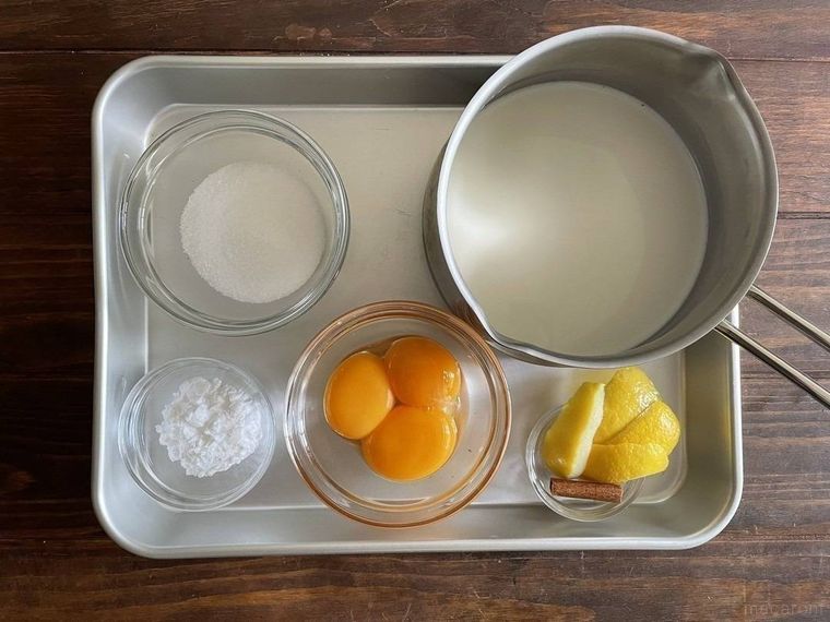 アルミのバットにのった、卵黄、牛乳、グラニュー糖、レモンの皮など