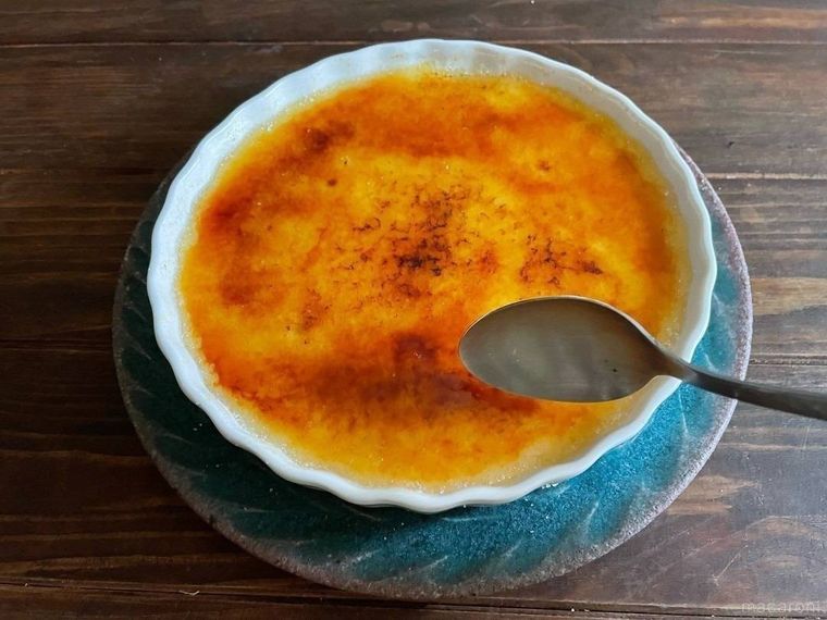 青い皿を敷き、陶器のパイ皿に入ったカタラーナ、スプーン