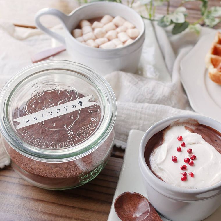 蓋付きの瓶に入ったミルクココアの素と、マシュマロやホイップクリームをトッピングしたココア