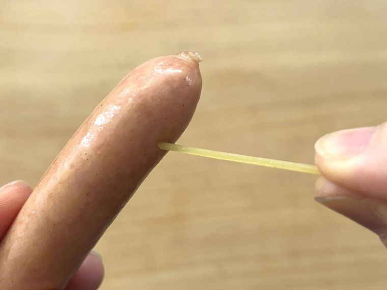 ウインナーに乾燥パスタを刺しているところ