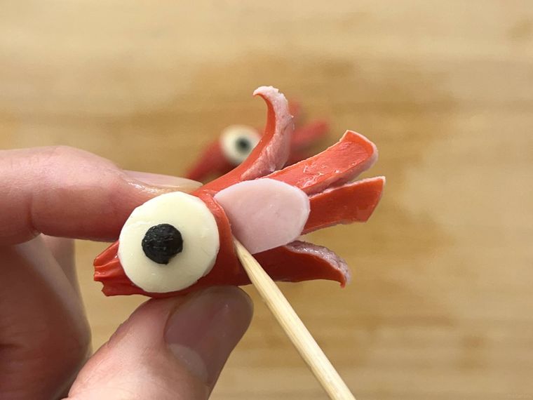 ひとつ目おばけウインナーにハムの舌を差し込んでいるところ