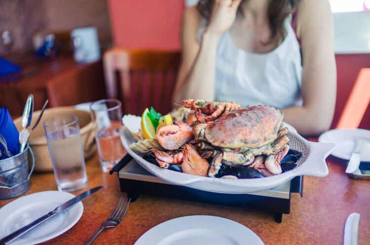 甲骨類の料理を目の前にする女性