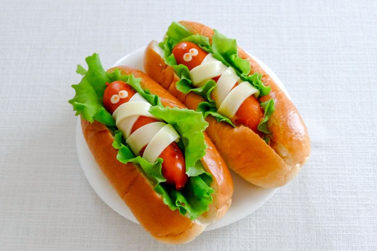 ぐるぐるミイラが挟まっているホットドッグサンドがふたつ並ぶ小皿