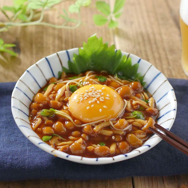 青い線入りの皿に入っているなめこのユッケ風