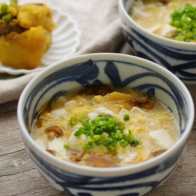和柄の椀に入っている豆腐となめこのかきたま汁