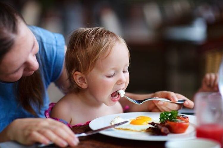 お母さんにご飯を食べさせてもらう子供の画像