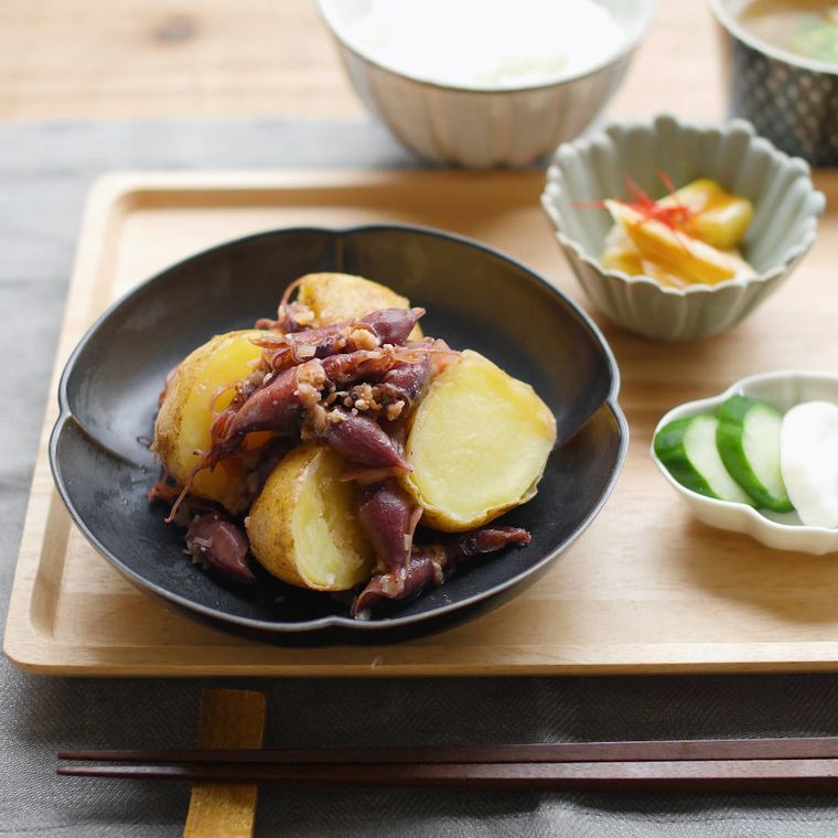 黒い皿に盛られたホタルイカの新じゃがバター炒め