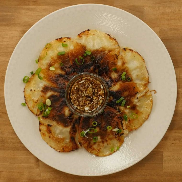 白い皿に盛りつけられた大葉とチーズの包まない餃子