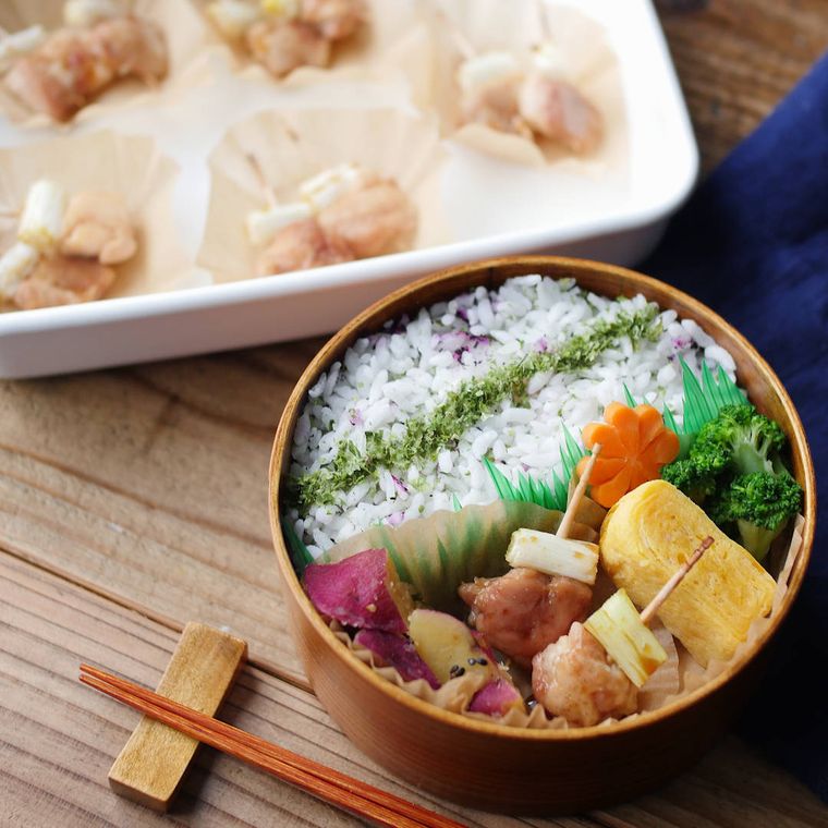 ねぎま焼き鳥、卵焼き、ふりかけごはんなどが入った、曲げわっぱのお弁当