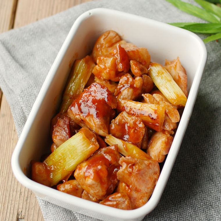 白い保存容器に入った、鶏肉と長ねぎのキムチ炒め