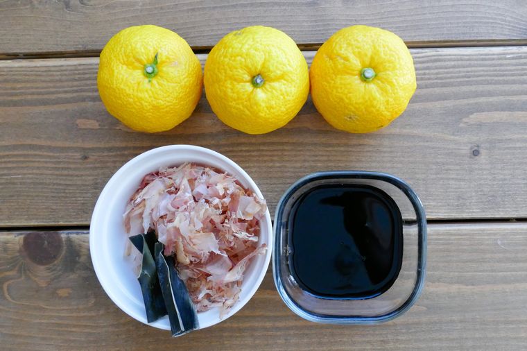 ゆず、かつおぶし、昆布、しょうゆが並ぶ木製テーブル