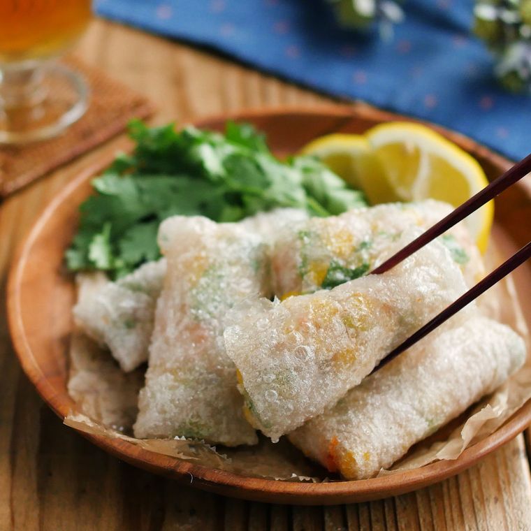 赤茶色の皿に盛りつけられたえびの揚げ生春巻きとつけ合わせ