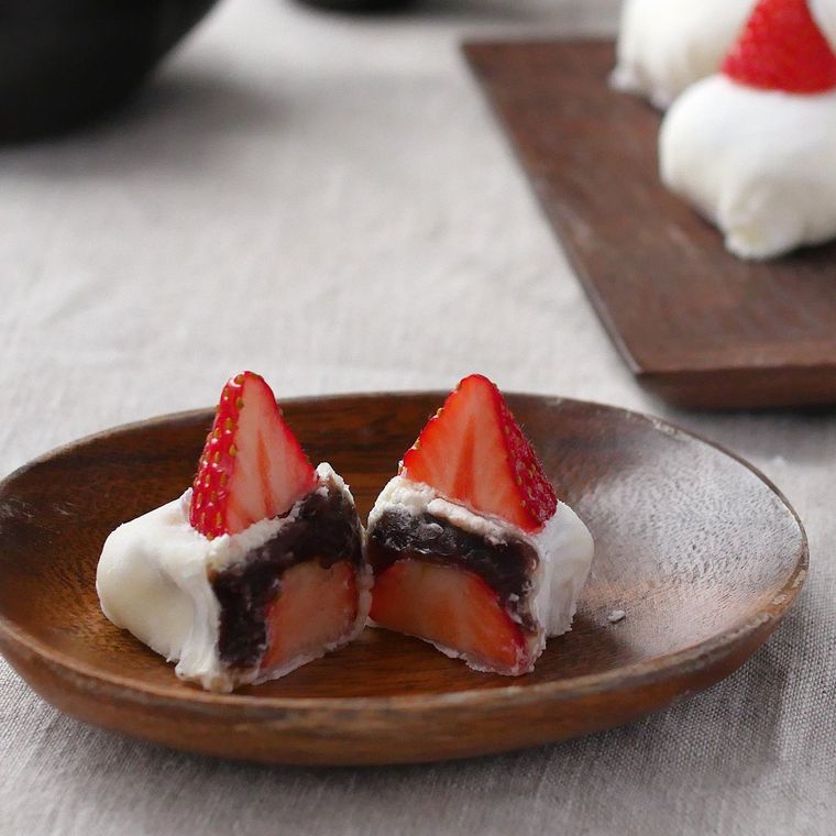 赤茶色の皿に盛りつけ半分にカットしたいちご大福風生春巻き