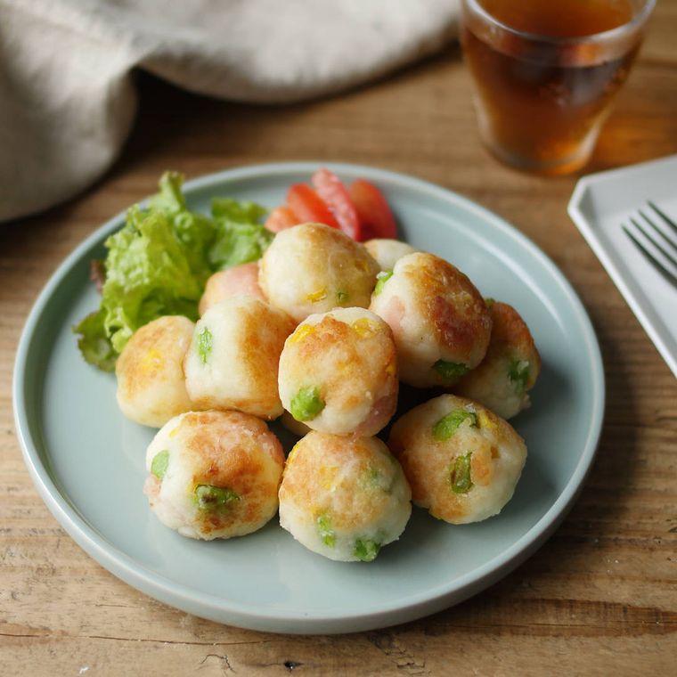 灰色の丸皿に付け合わせの野菜と一緒に盛られた、はんぺん焼き