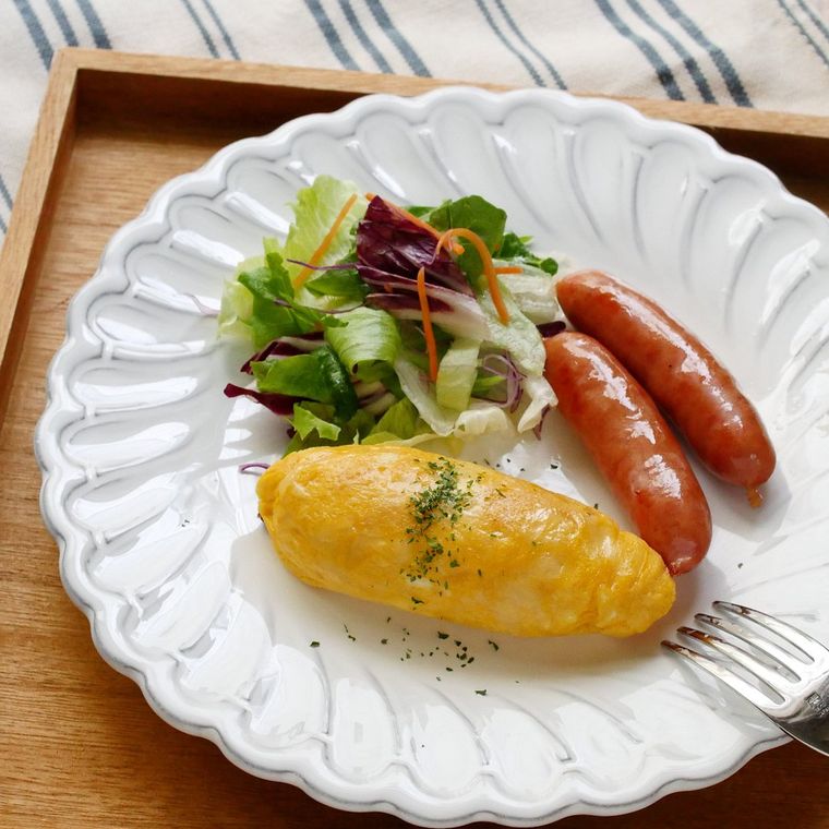 白い皿に付け合わせの野菜やウインナーソーセージと一緒に盛られた、ふわふわオムレツ
