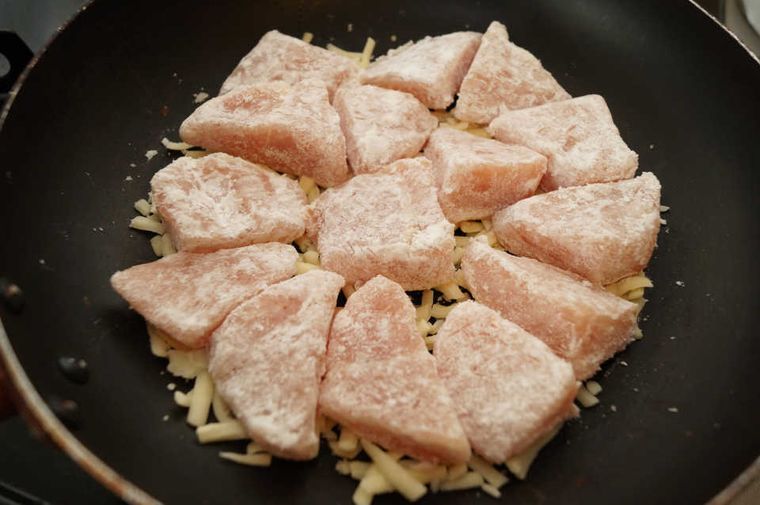 チーズの上に鶏胸肉を並べている写真