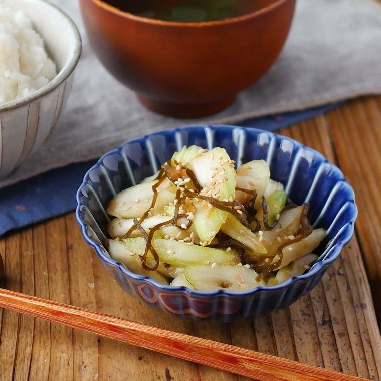 青い小鉢に盛られたセロリの梅風味サラダとごはんの食卓