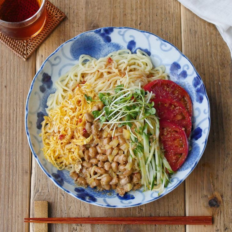 丸皿にかいわれ大根添えピリ辛納豆冷やし中華が盛られている