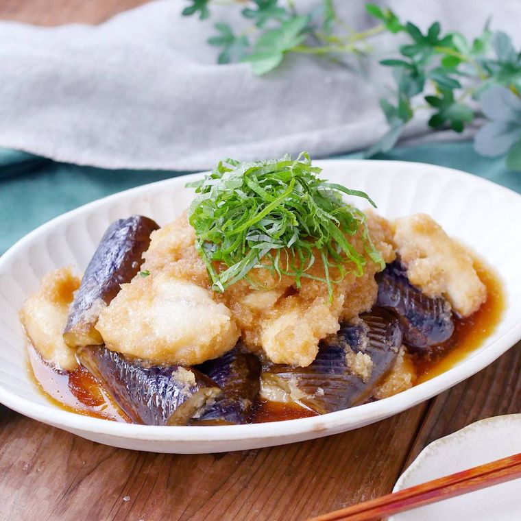 白い皿に盛りつけ大葉がトッピングされた鶏肉と焼きなすのみぞれ煮