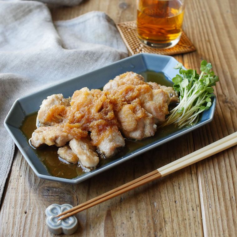 青い角皿に盛りつけられた鶏もも肉のおろしポン酢とかいわれ大根