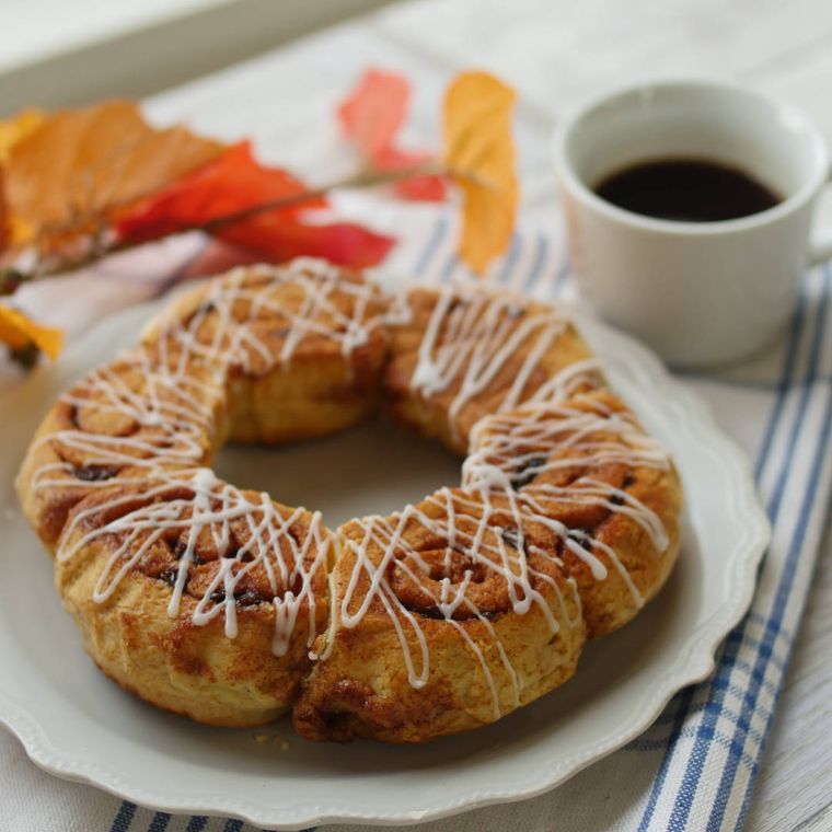 白いプレートにのせられた、ちぎって食べられるシナモンロール