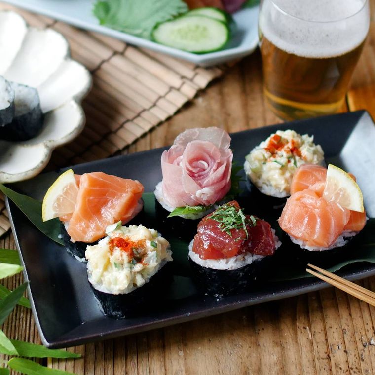 黒い皿に入ったサーモンやまぐろなどの寿司