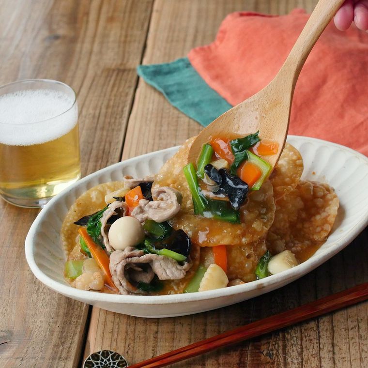 パリパリの海鮮おこげあんかけをスプーンですくっているところ