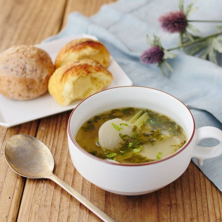 縁取りのある白いカップに盛りつけられたかぶとひき肉のスープ