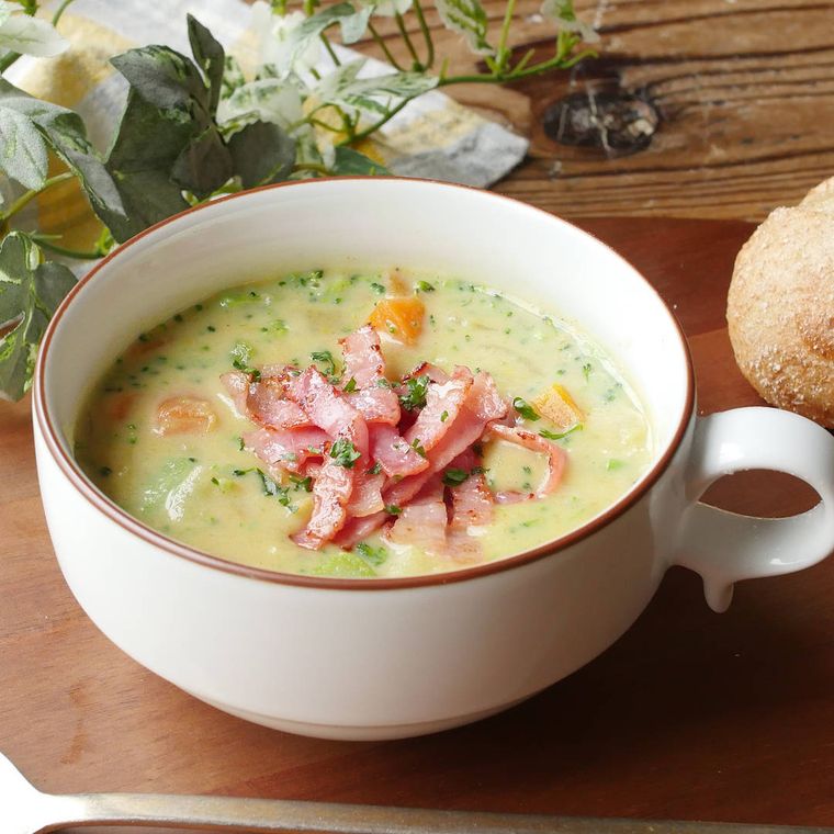 木製プレートにのせた、持ち手付きスープボウルに盛り付けたブロッコリーのカレーチャウダー